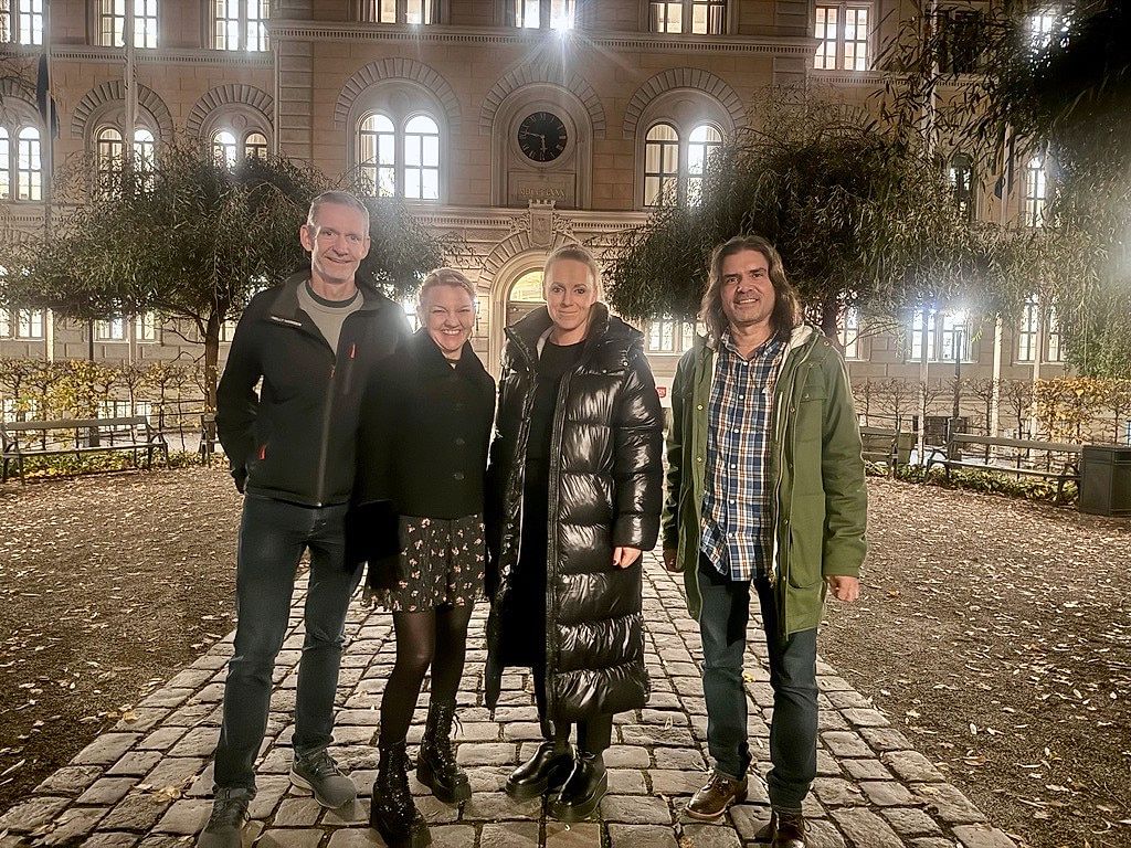 Fyra konsulter från Konkret som arbetar med Bob och iBob, på en innergård i kvällsljus